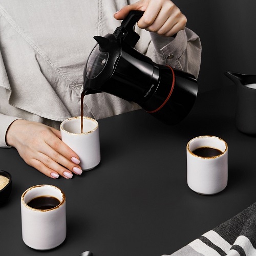 Девушка разливает кофе из гейзерной кофеварки